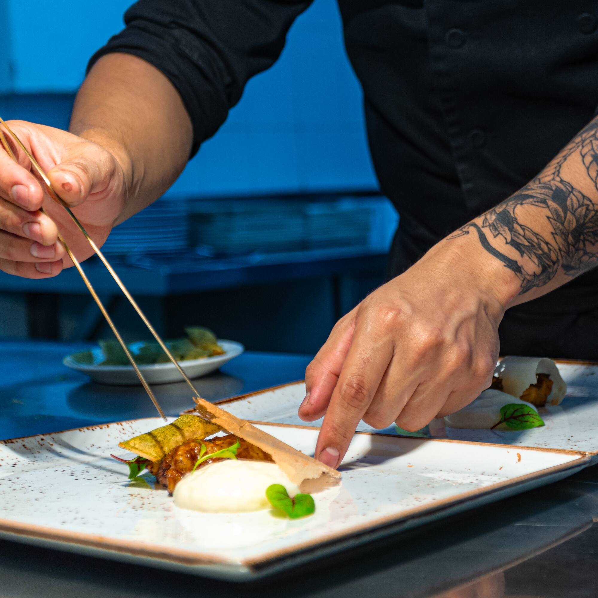 a person holding chopsticks over a plate of food