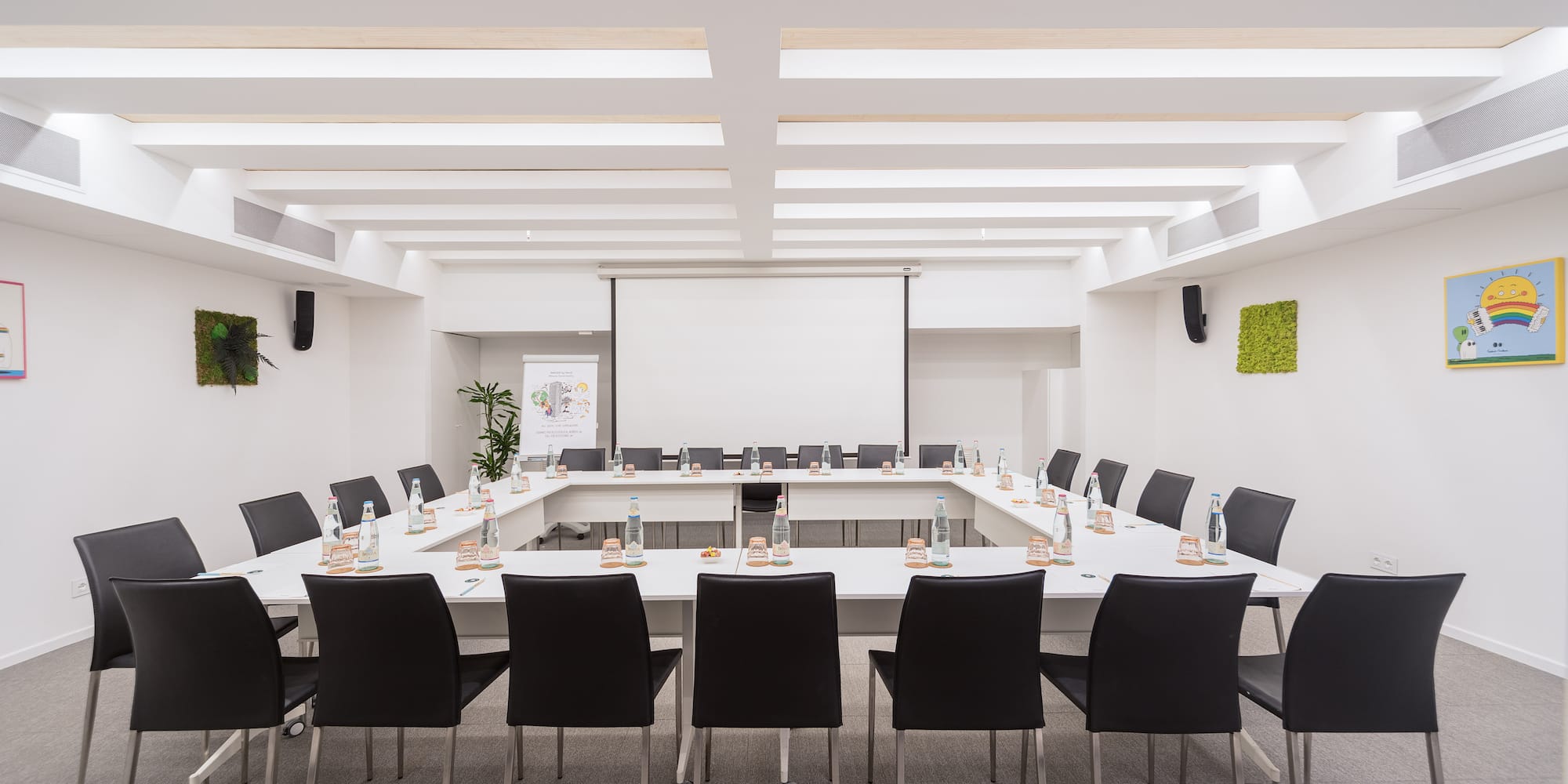 a room with a white boardroom with tables and chairs