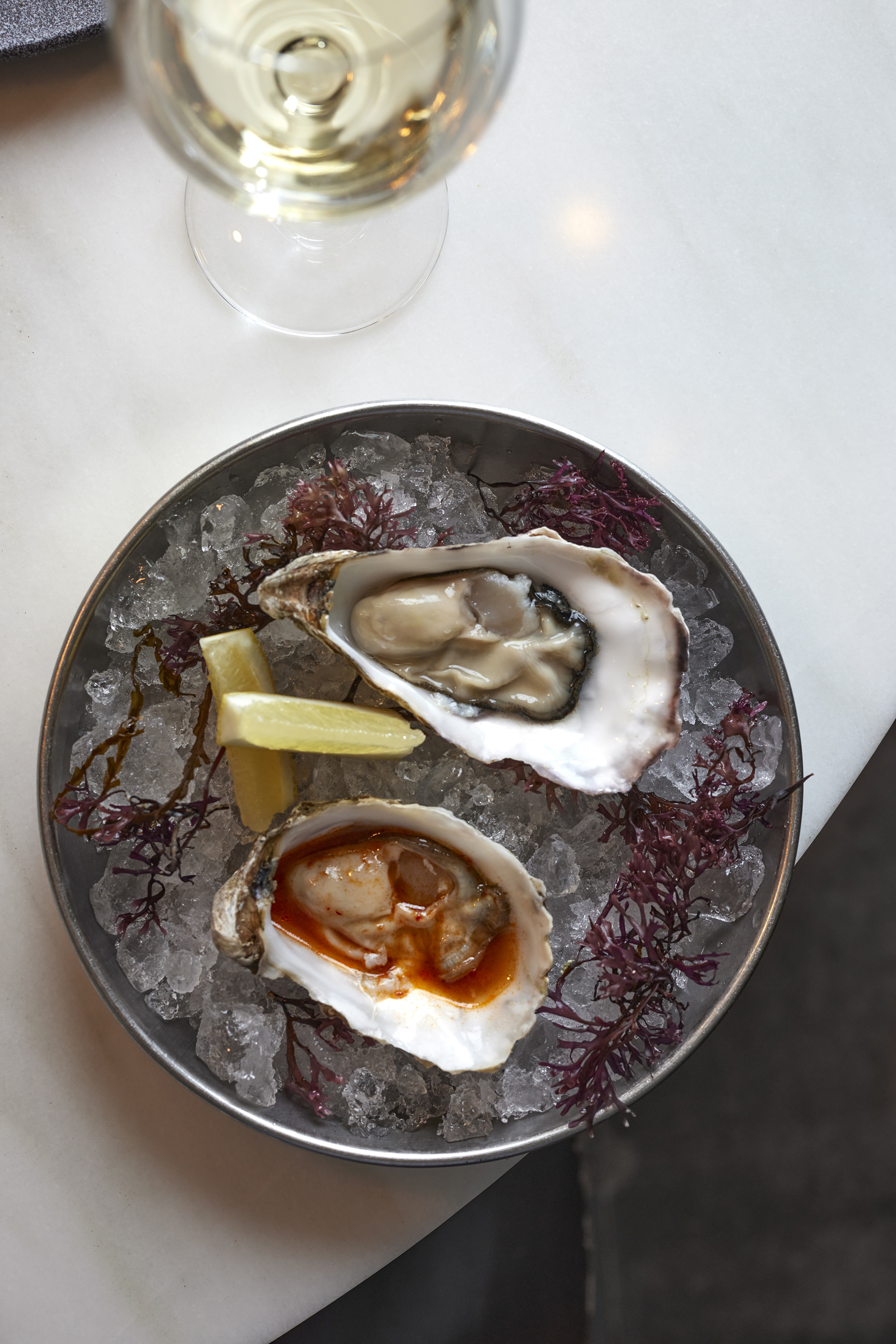 a plate of oysters and lemon wedges