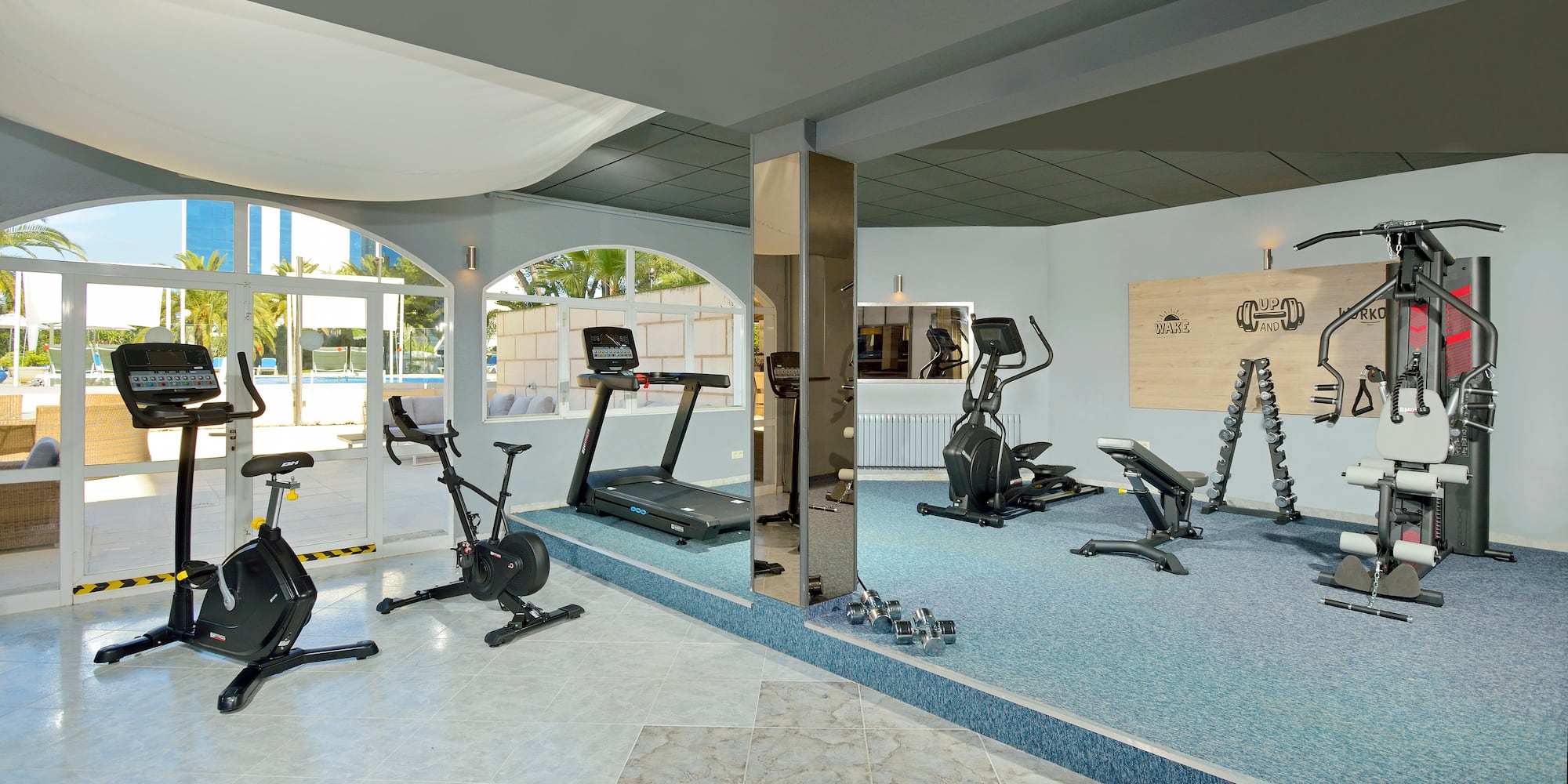 a room with exercise machines and a mirror