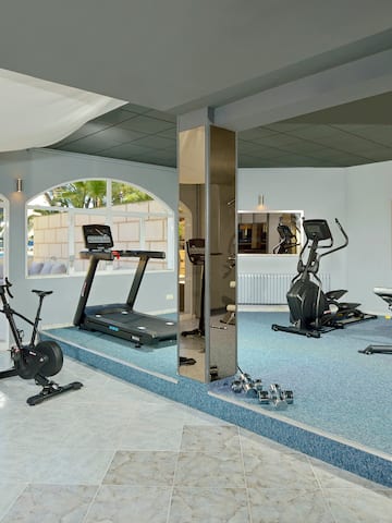 a room with exercise machines and a mirror