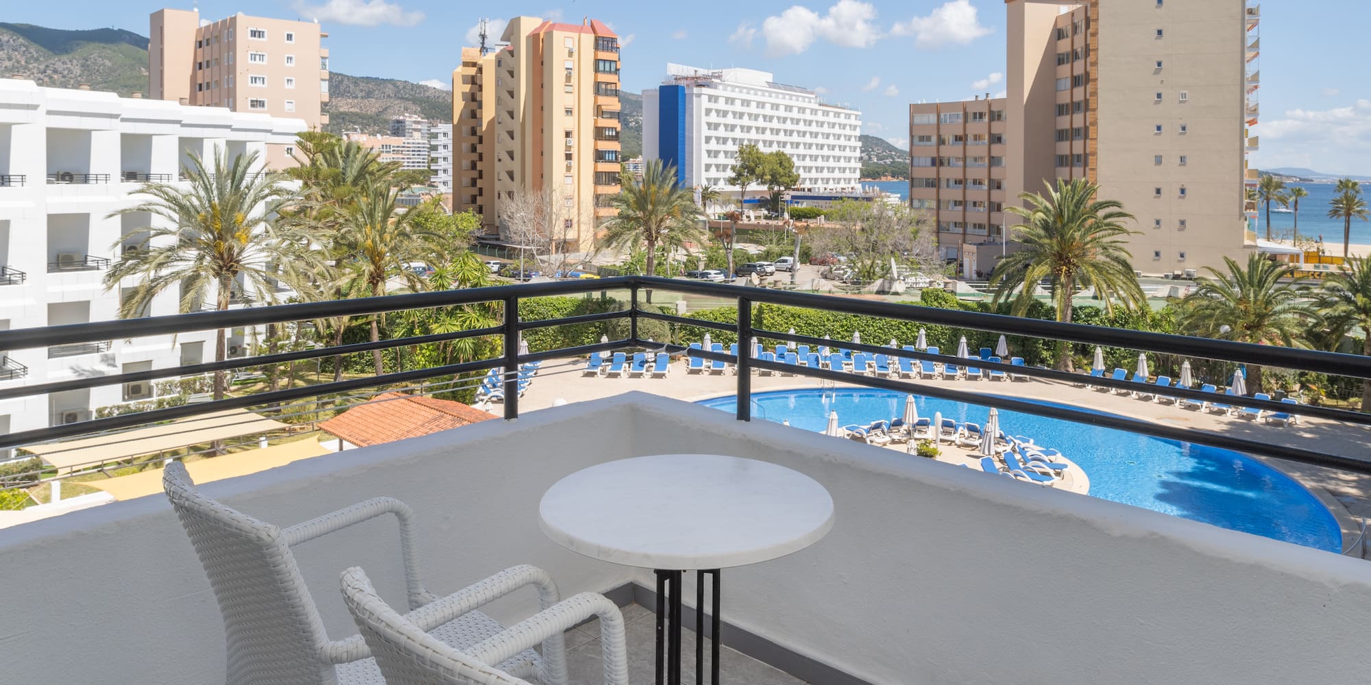 a balcony with a pool and chairs