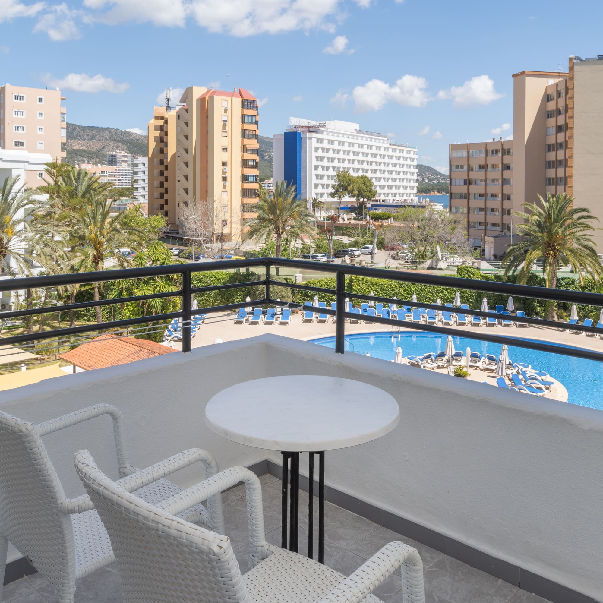 a balcony with a pool and chairs