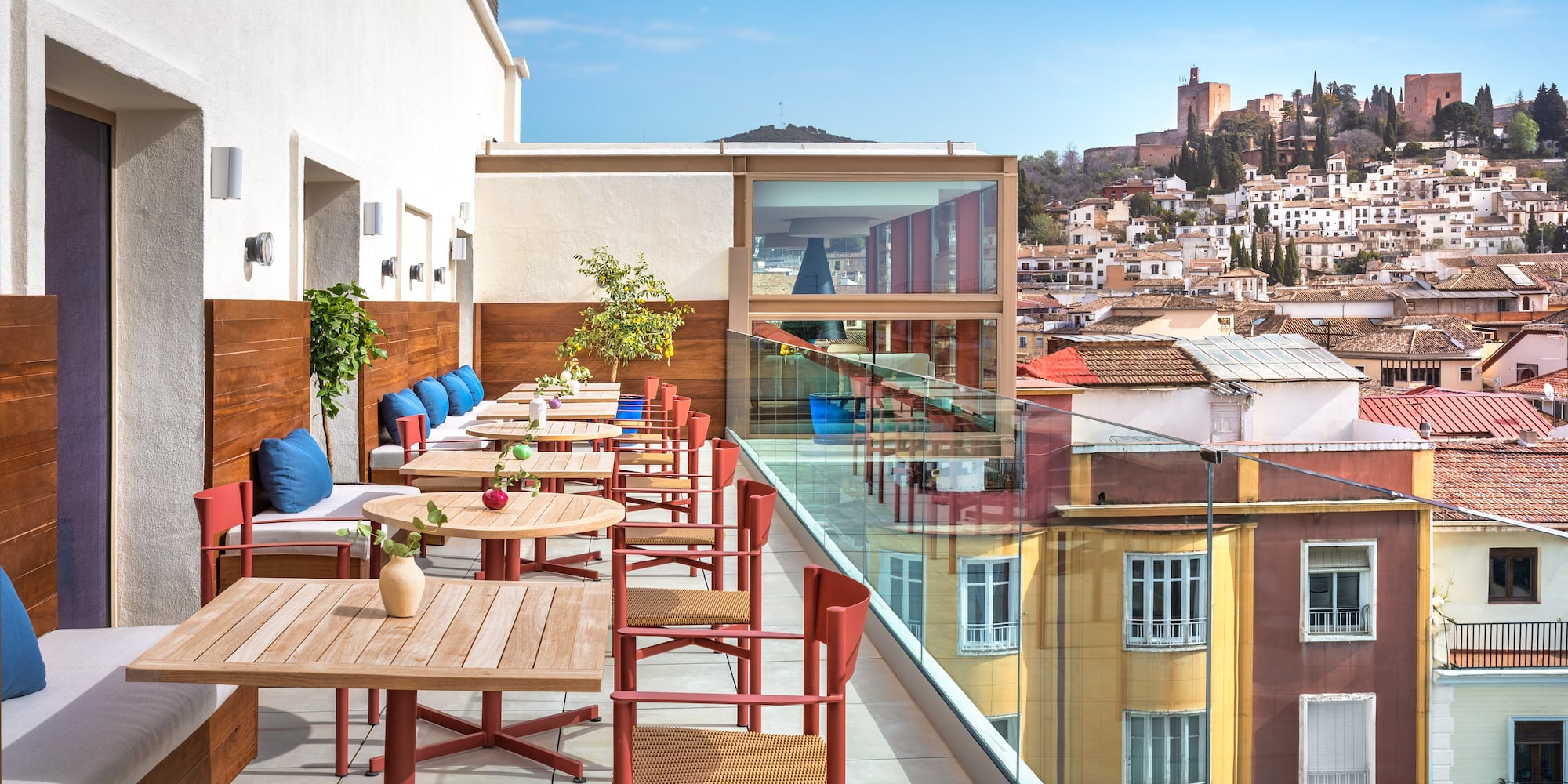 a table and chairs on a balcony with a city in the background