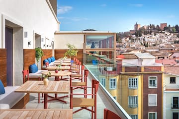 a table and chairs on a balcony with a city in the background