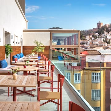 a table and chairs on a balcony with a city in the background