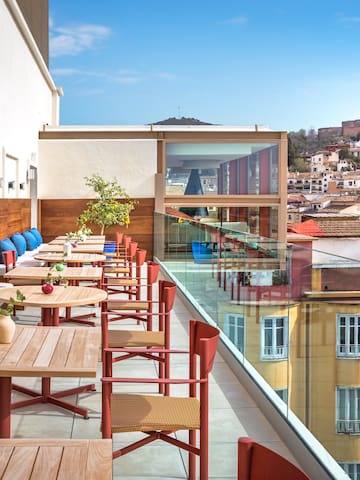 a table and chairs on a balcony with a city in the background