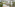Resort pool area with pergola, thatched gazebo, lounge chairs, and palm trees.