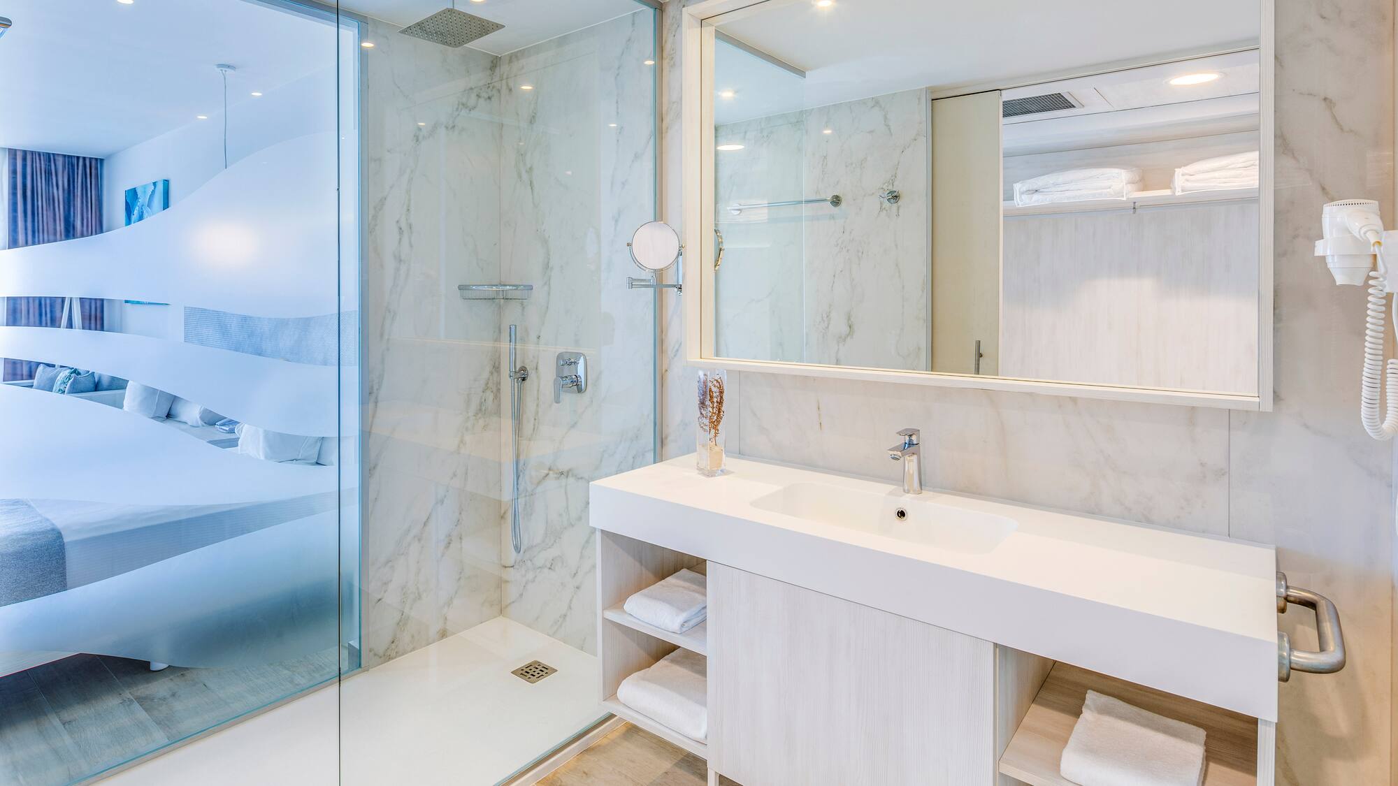 a bathroom with a glass shower and a sink