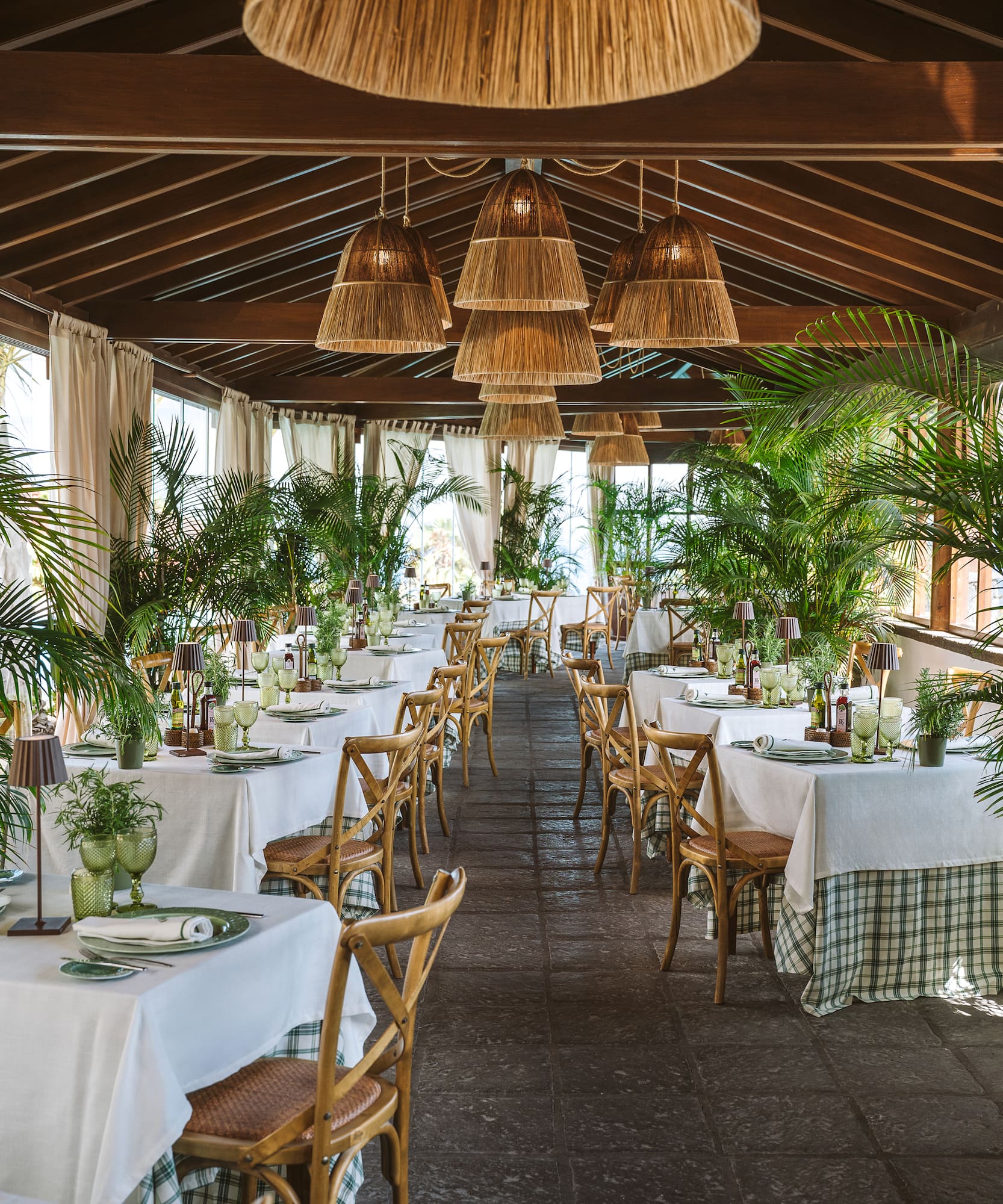 a room with tables and chairs and plants
