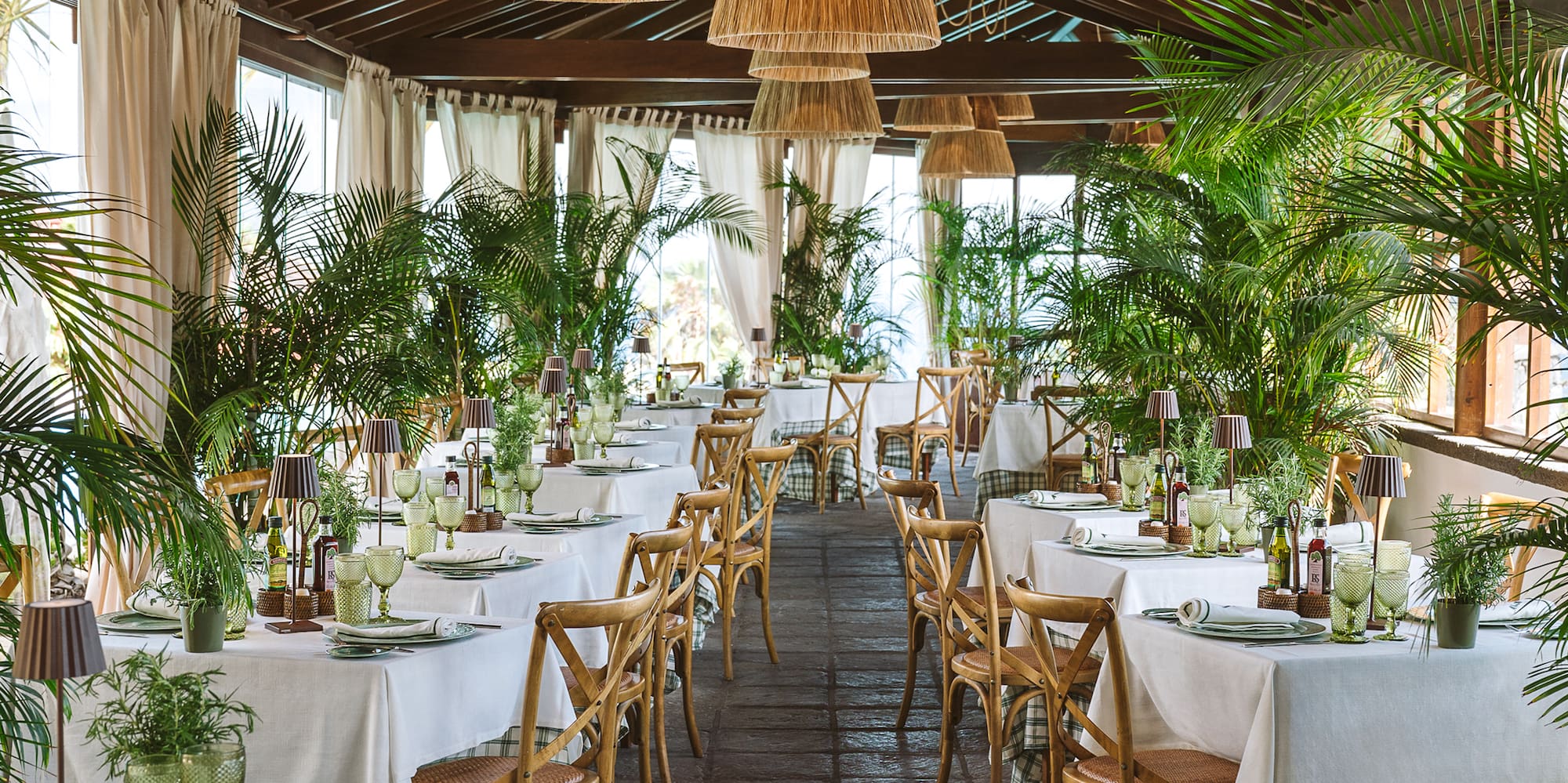 a room with tables and chairs and plants
