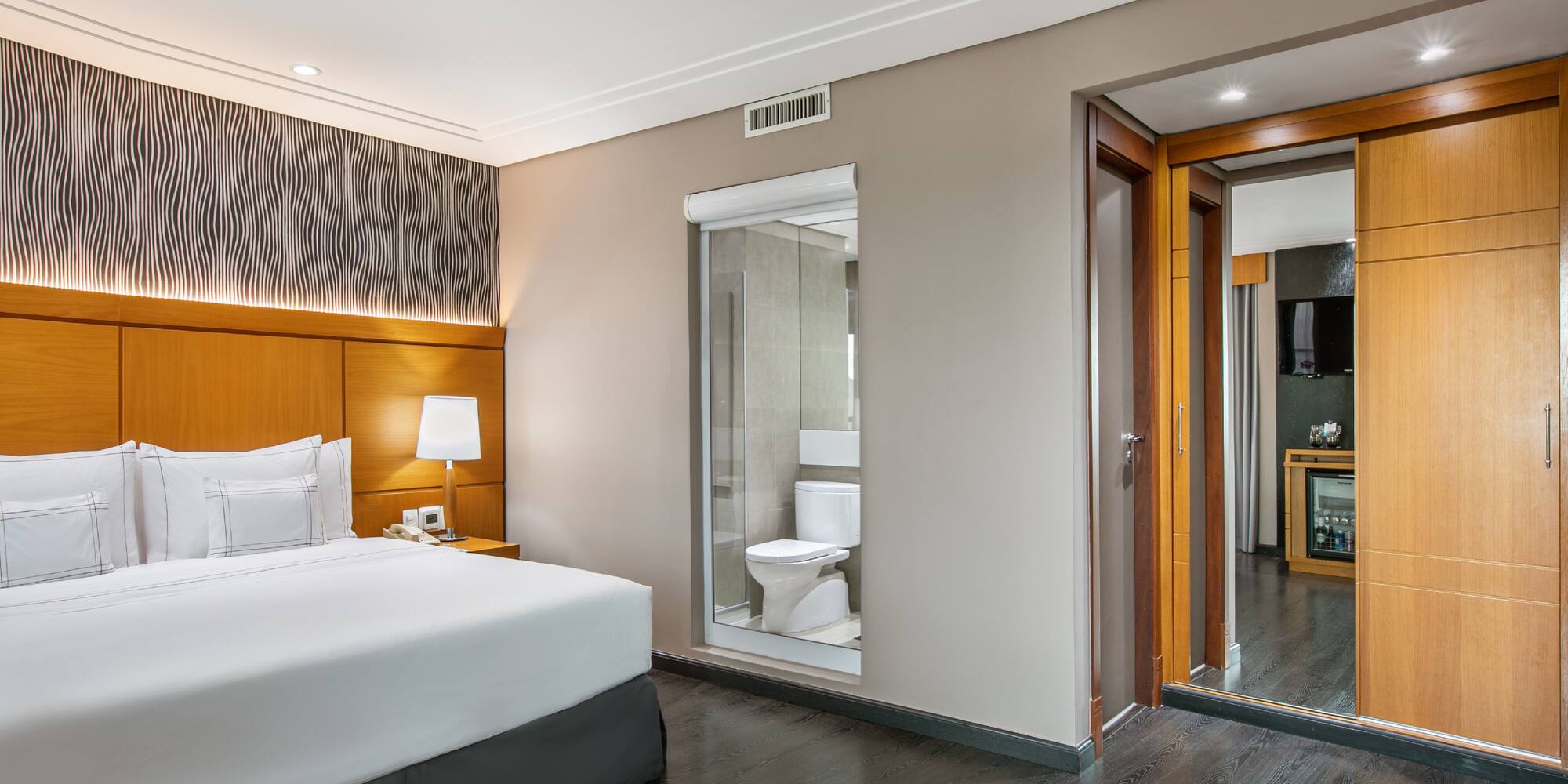 a bedroom with a wood floor and a white bed