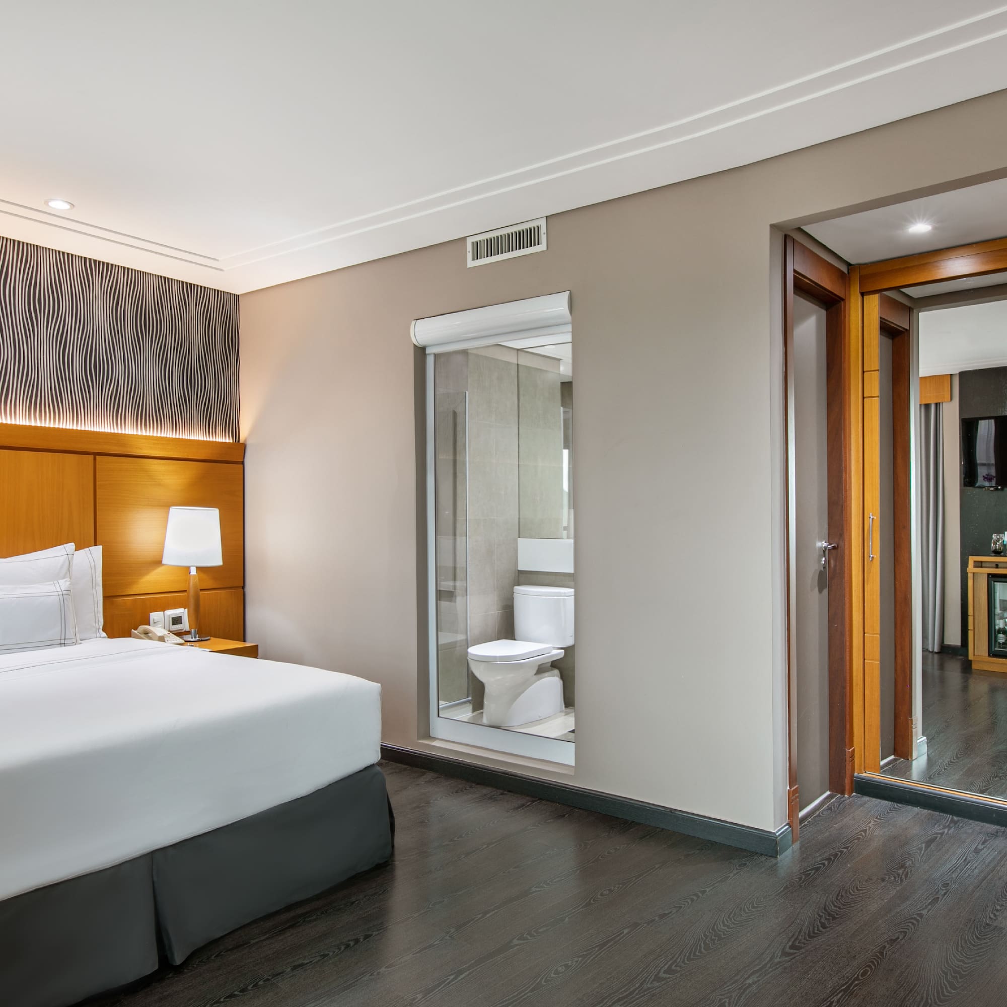 a bedroom with a wood floor and a white bed