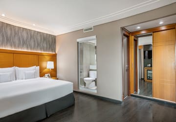 a bedroom with a wood floor and a white bed