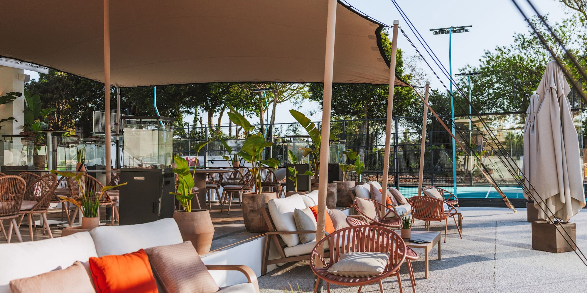 a patio with chairs and tables and a pool