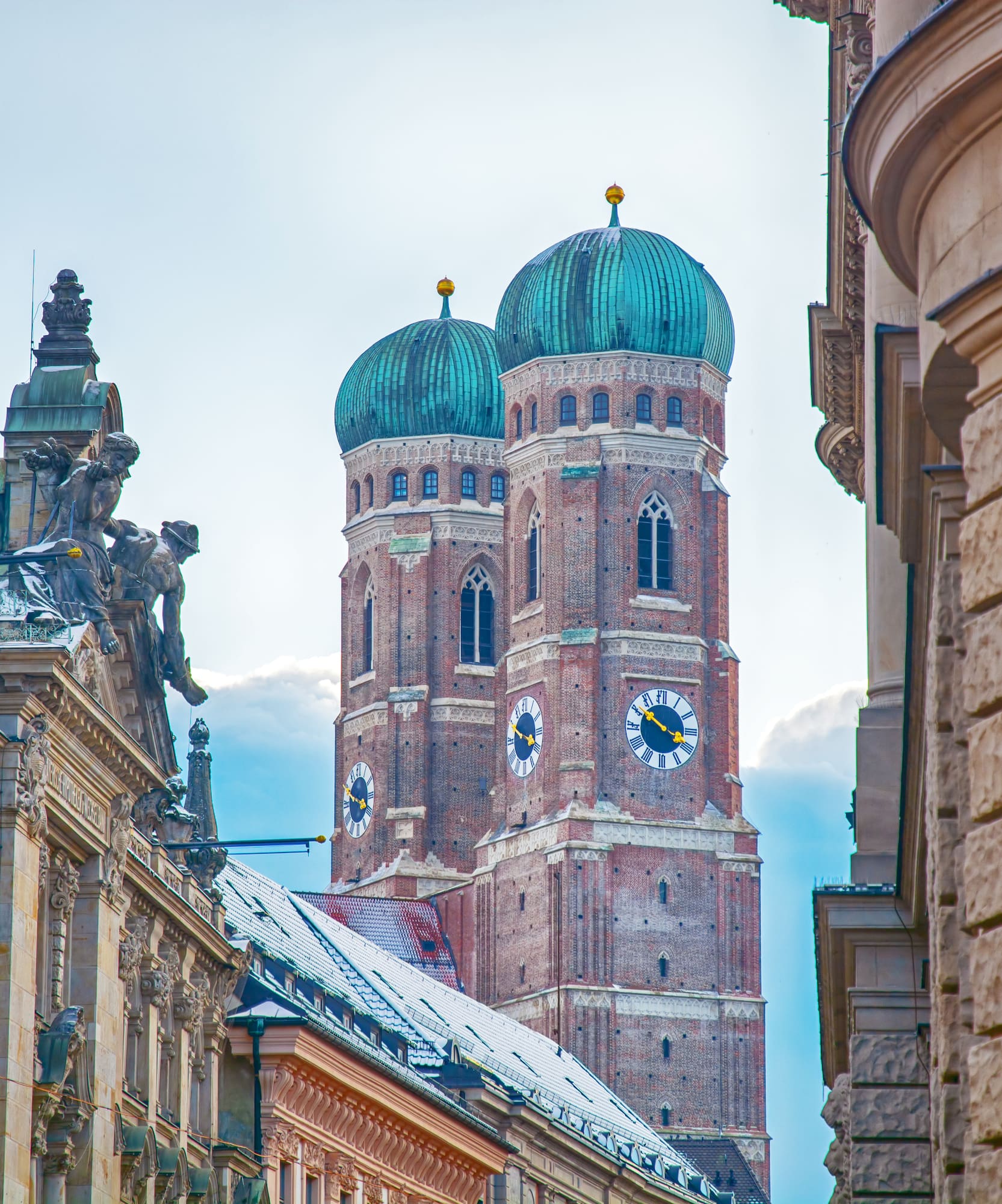 Frauenkirche Múnich: torres góticas de ladrillo, cúpulas verdes, edificios históricos.