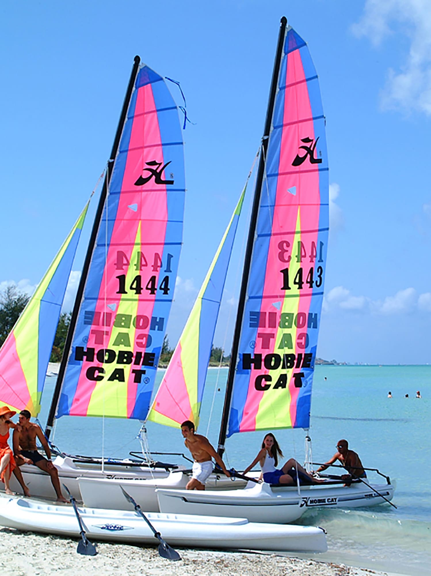 a group of people on a sailboat on a beach