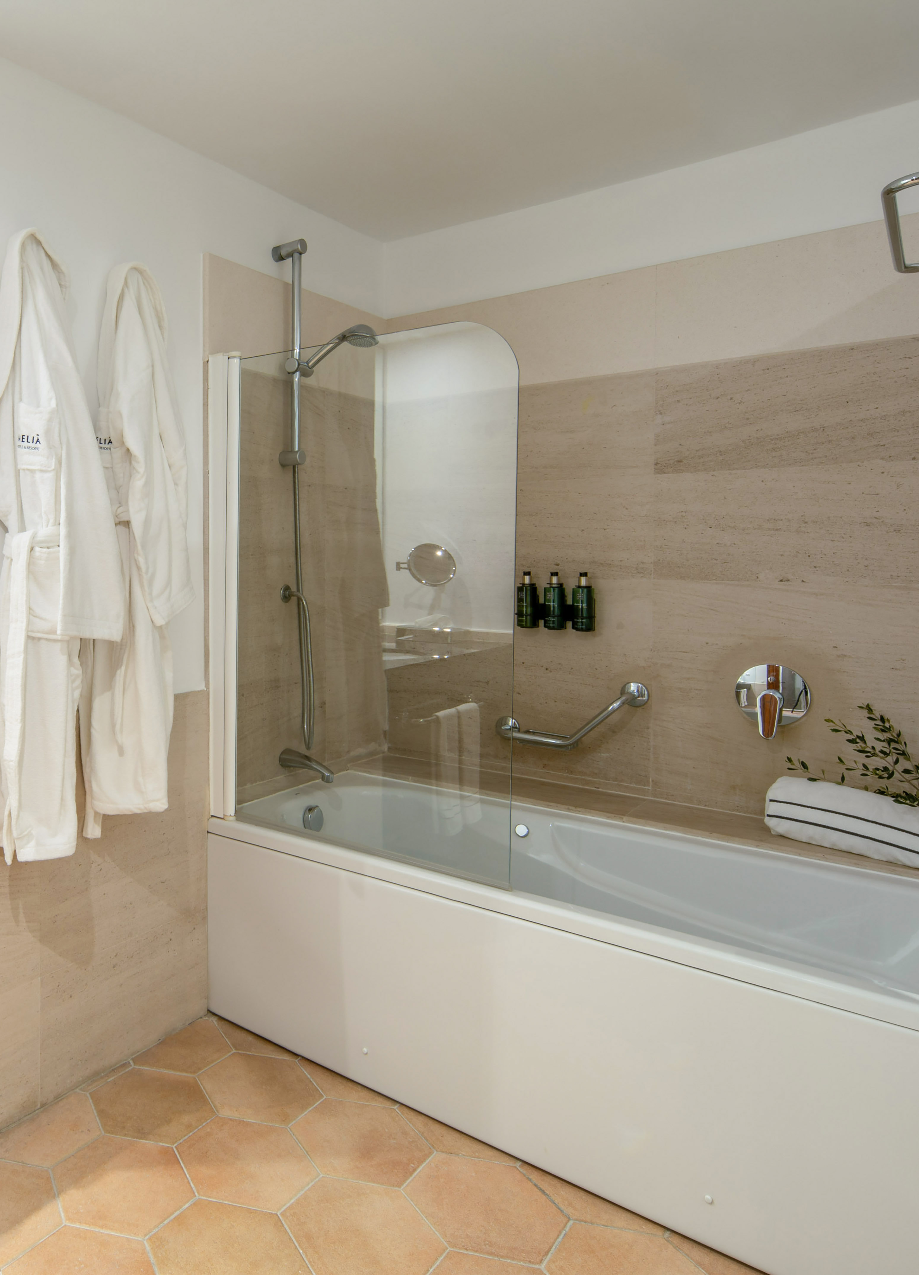 Modern hotel bathroom with shower-bathtub, white bathrobes, and tiled floor. - Junior Suite con Angolo Cottura - Meliá Cala d'Or Boutique Hotel, Maiorca