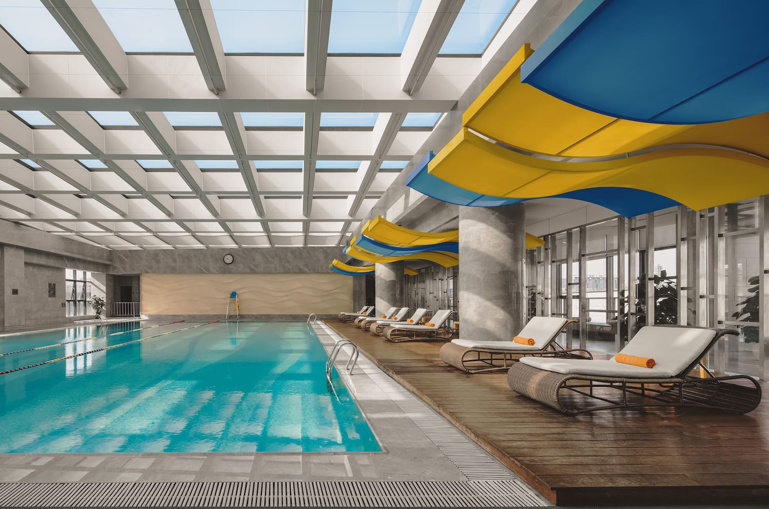 a swimming pool with lounge chairs and a large ceiling