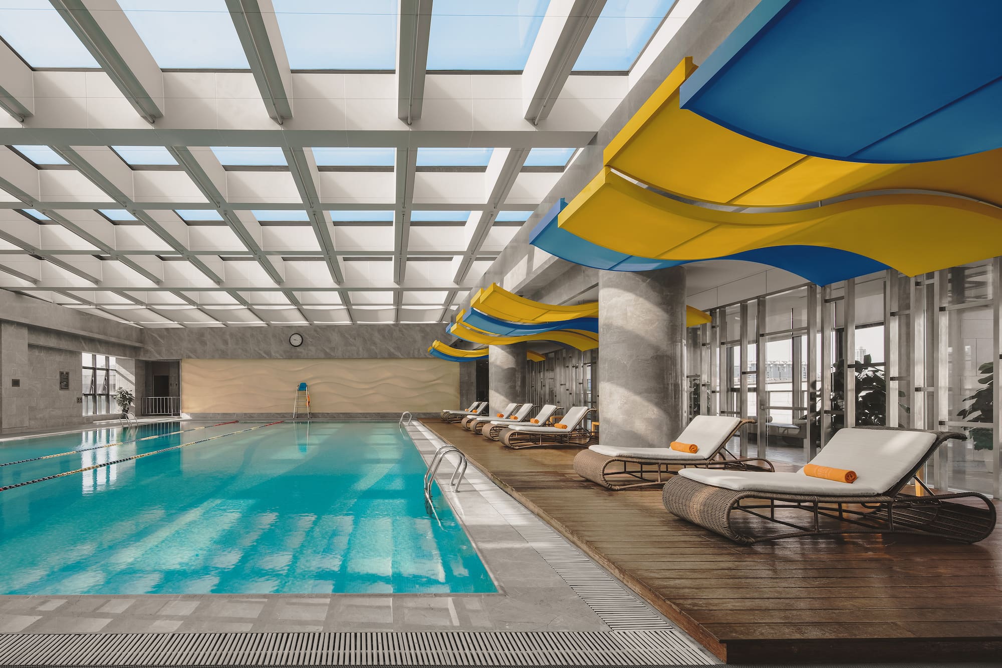 a swimming pool with lounge chairs and a large ceiling