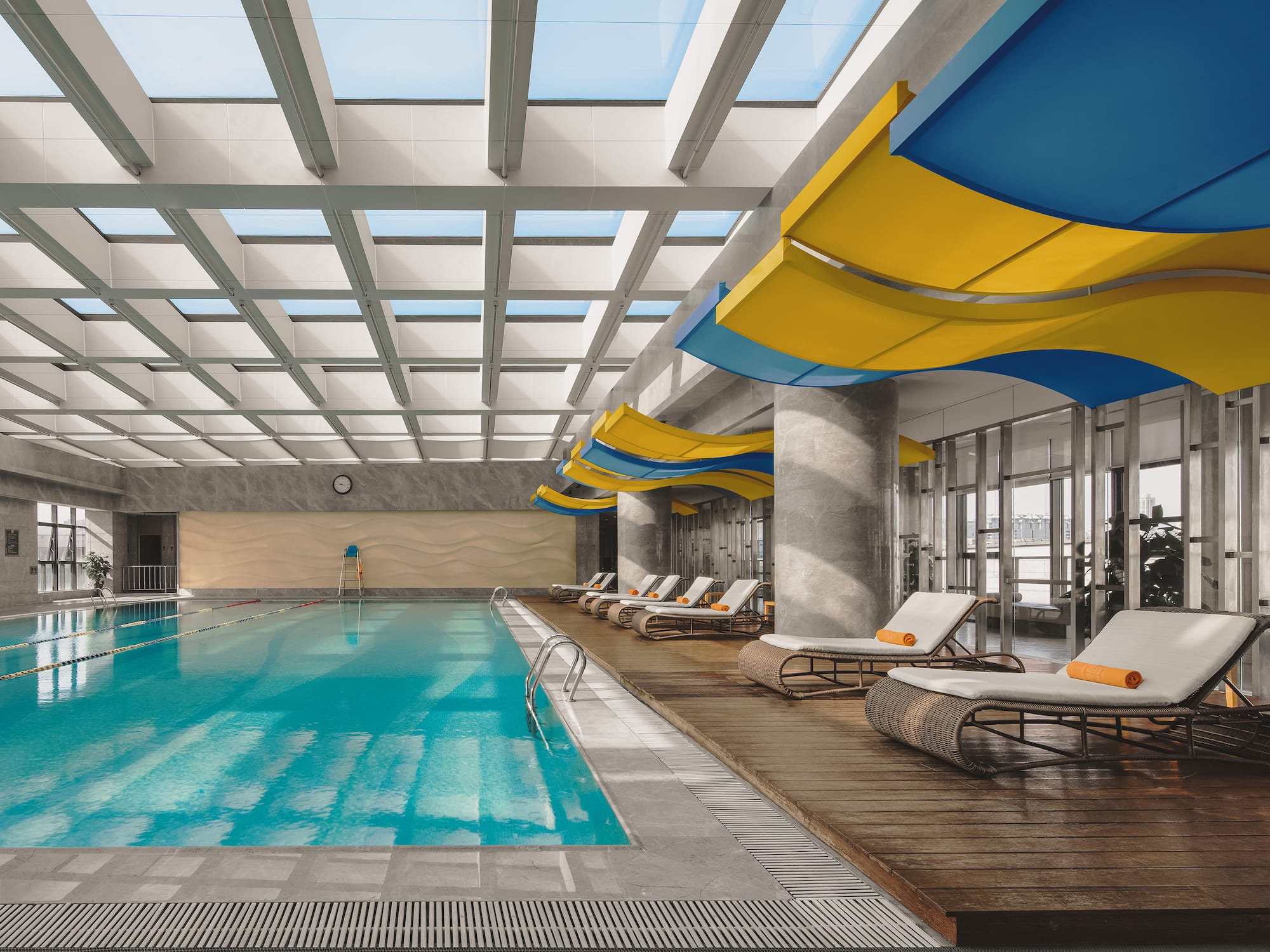 a swimming pool with lounge chairs and a large ceiling