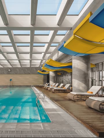 a swimming pool with lounge chairs and a large ceiling