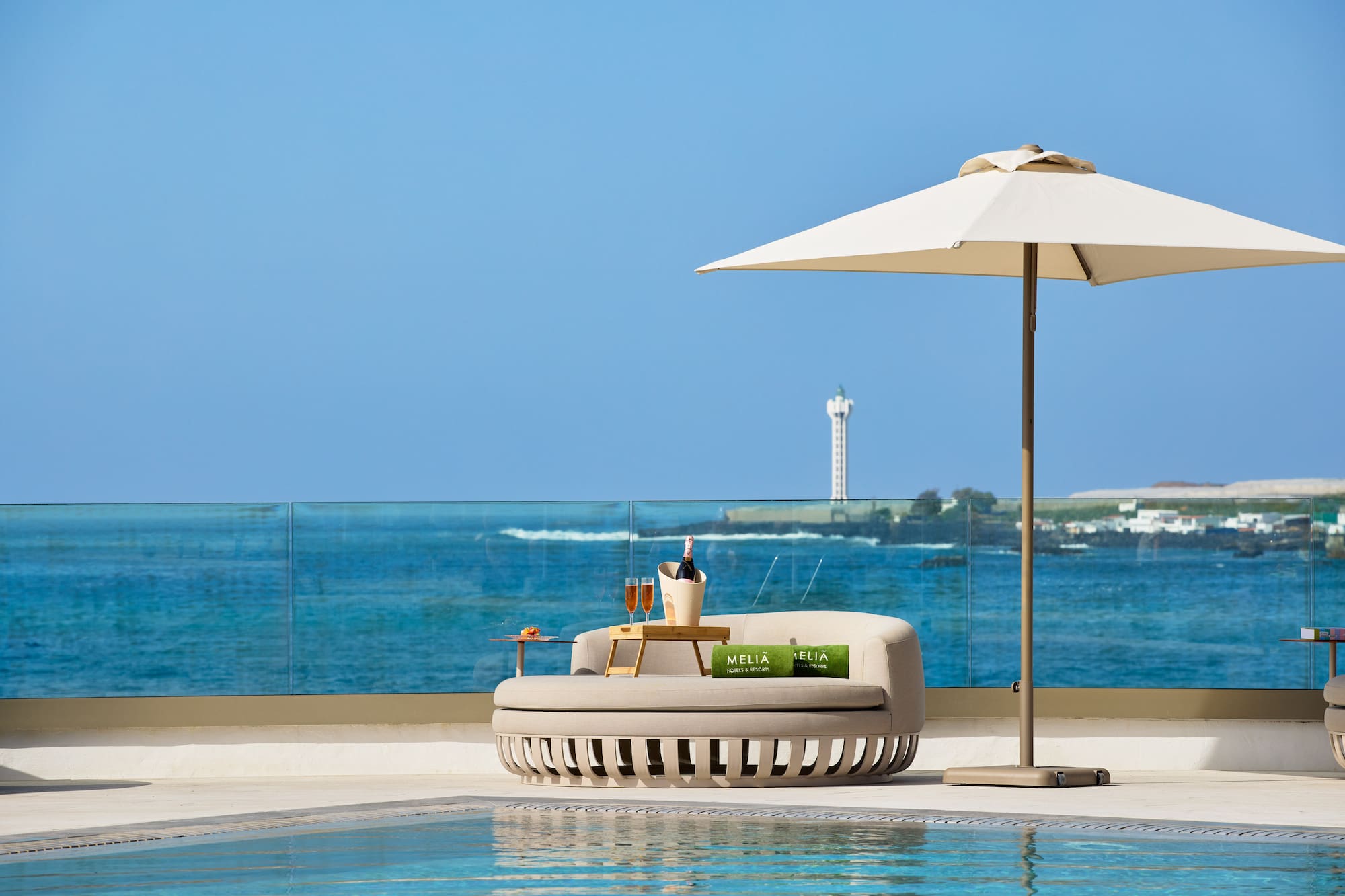 Meliã luxury hotel poolside daybed, champagne, and ocean view.