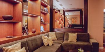 a couch with pillows in a room with shelves and a mirror