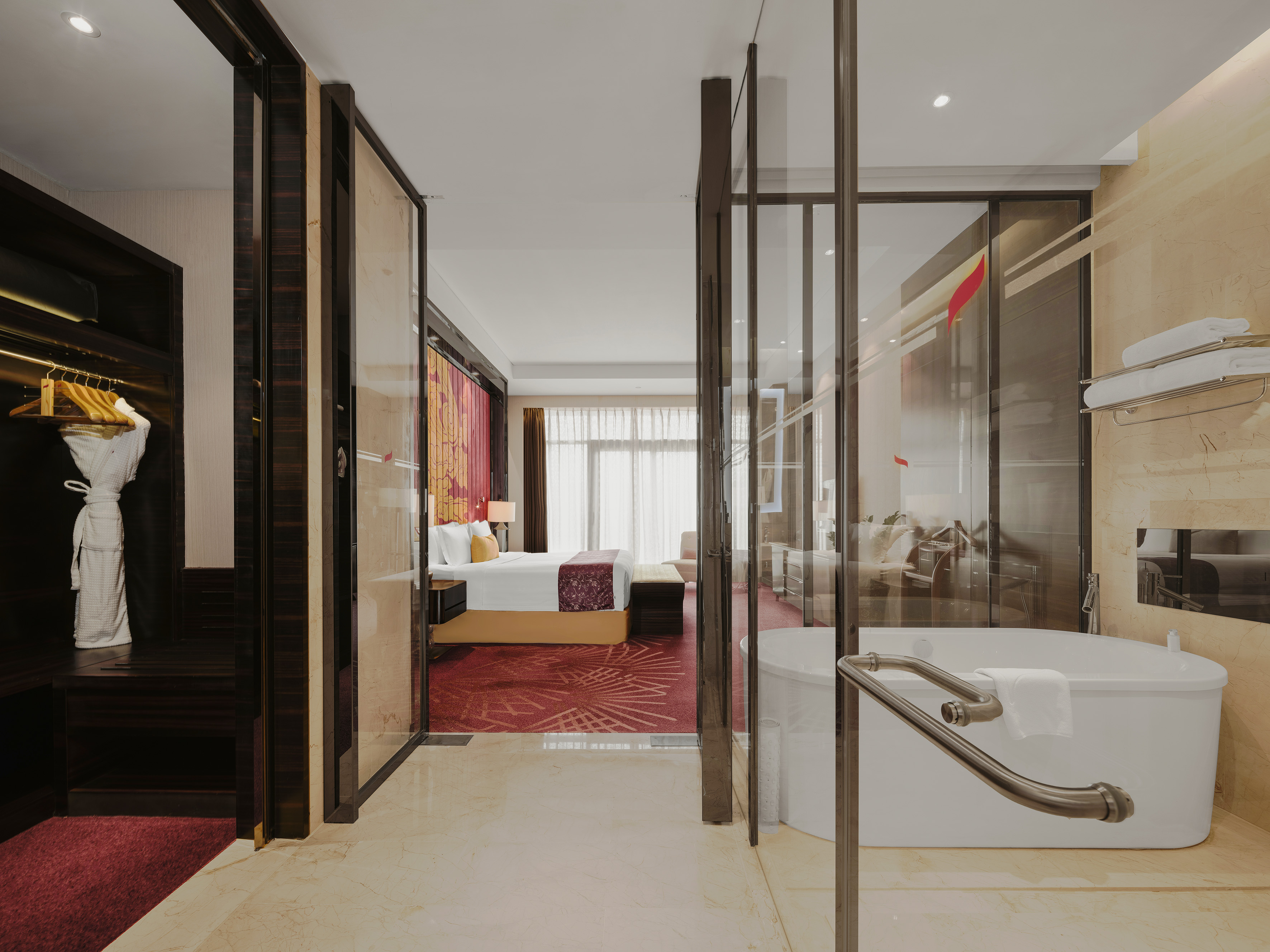 Luxury hotel suite with modern bedroom, bathtub, and walk-in closet.
