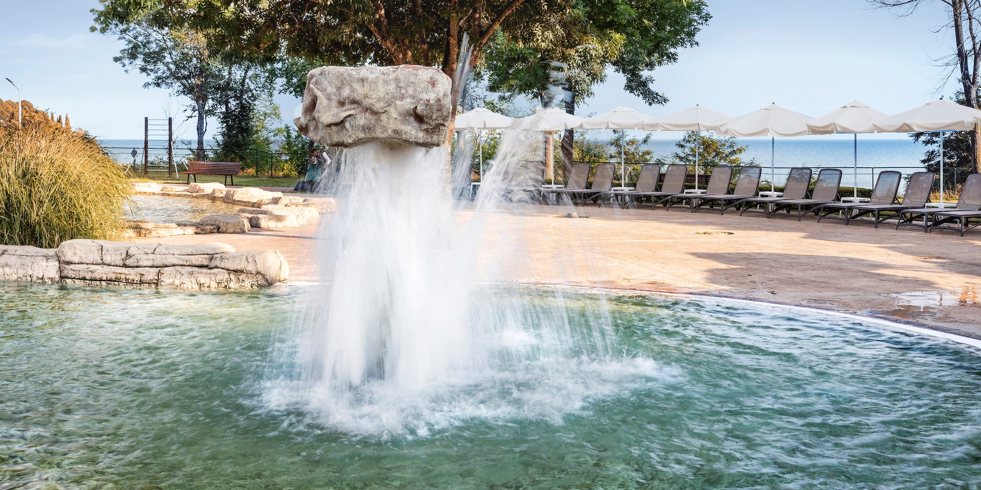 a water fountain with a rock in the air
