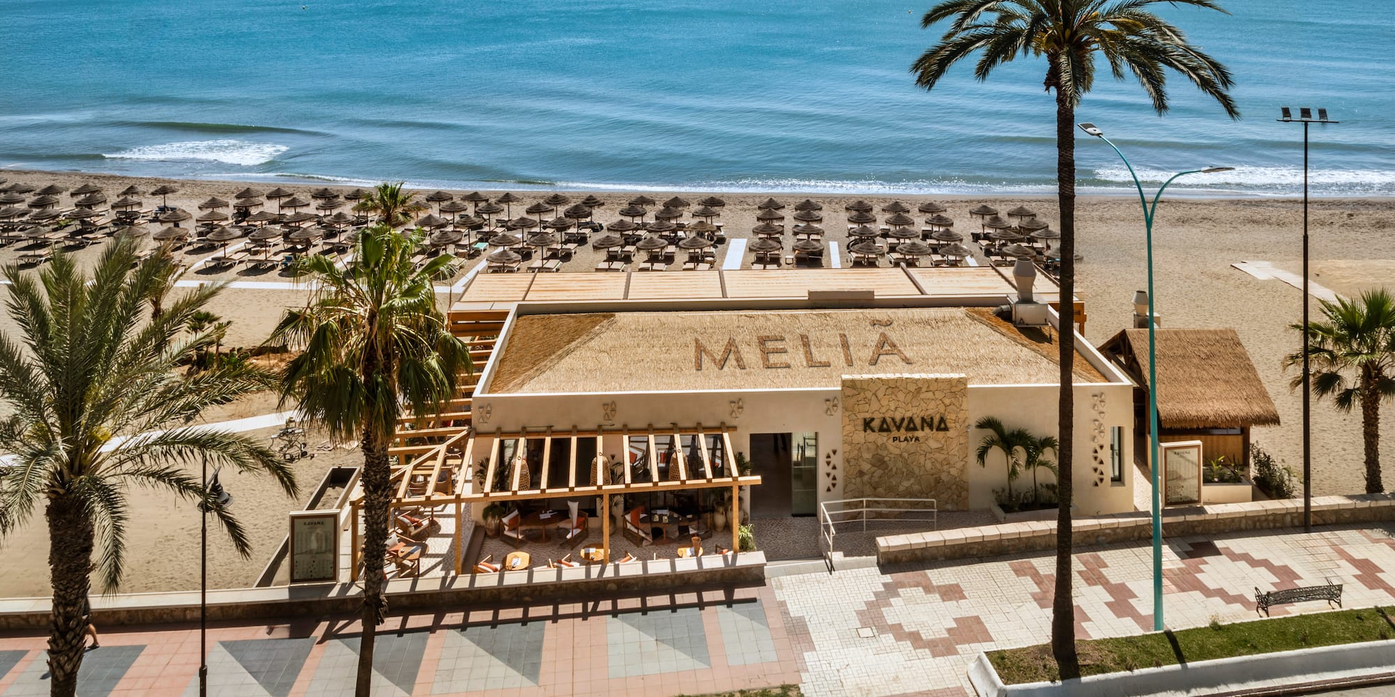 Melia Kavana Playa beach club with ocean, sunbeds, and palm trees.