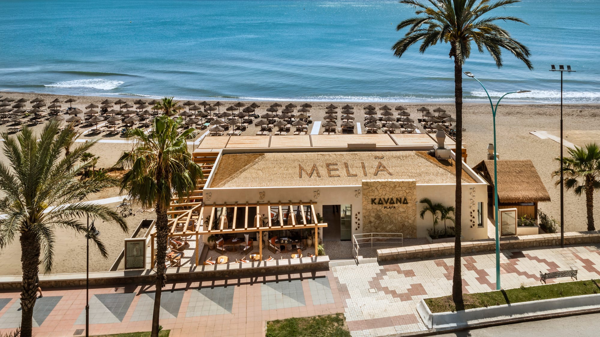 Melia Kavana Playa beach club with ocean, sunbeds, and palm trees.
