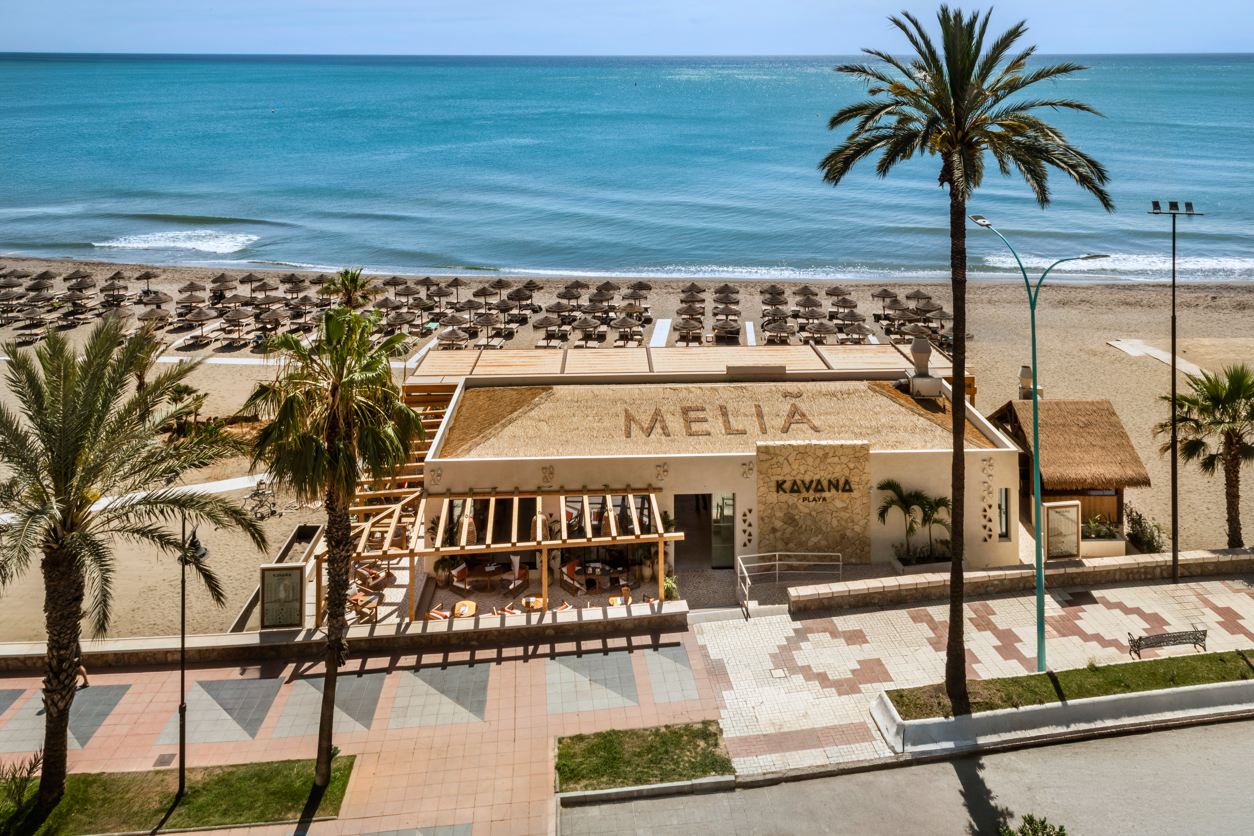 Melia Kavana Playa beach club with ocean, sunbeds, and palm trees.