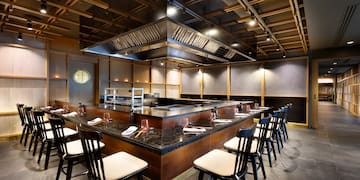 a restaurant with a large counter and chairs