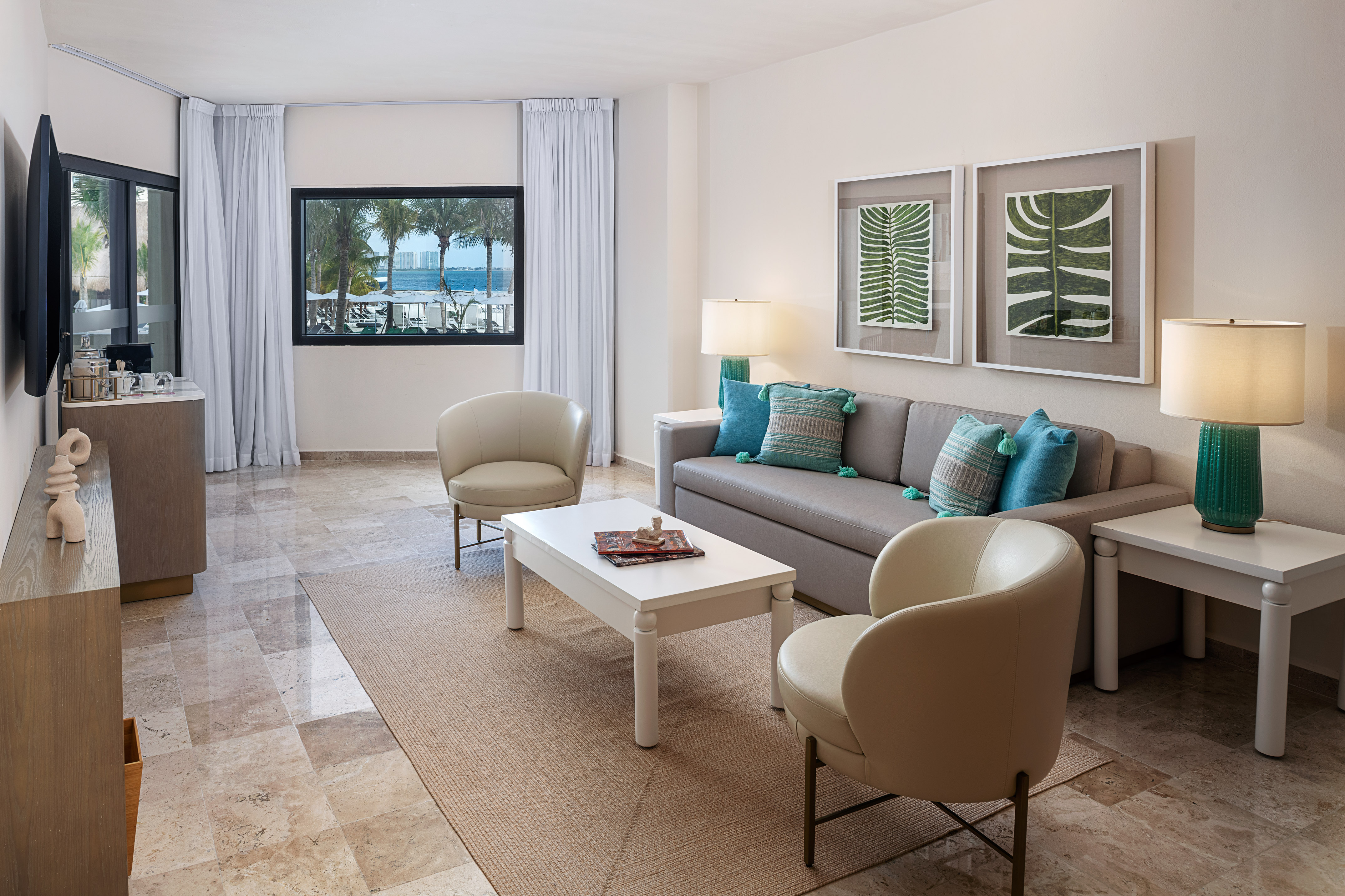 Modern living room suite with tropical ocean view, sofa, and stylish decor.