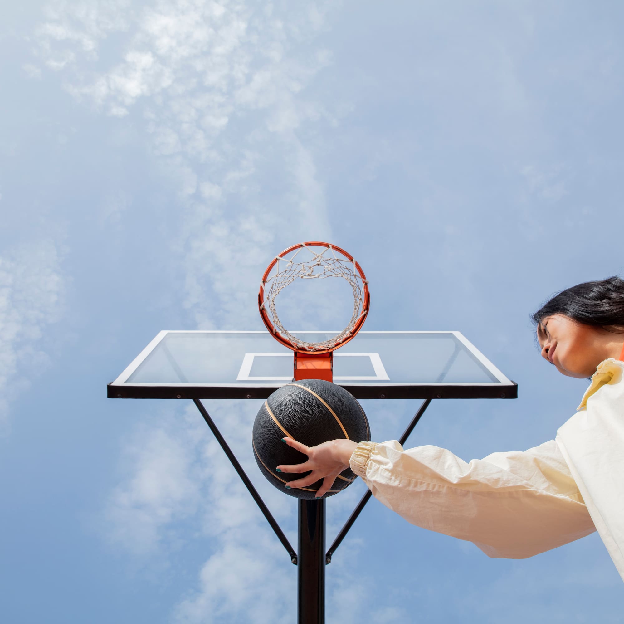 a woman playing basketball outside