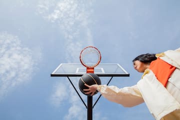 a woman playing basketball outside