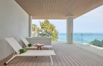 a deck with a jacuzzi overlooking the ocean