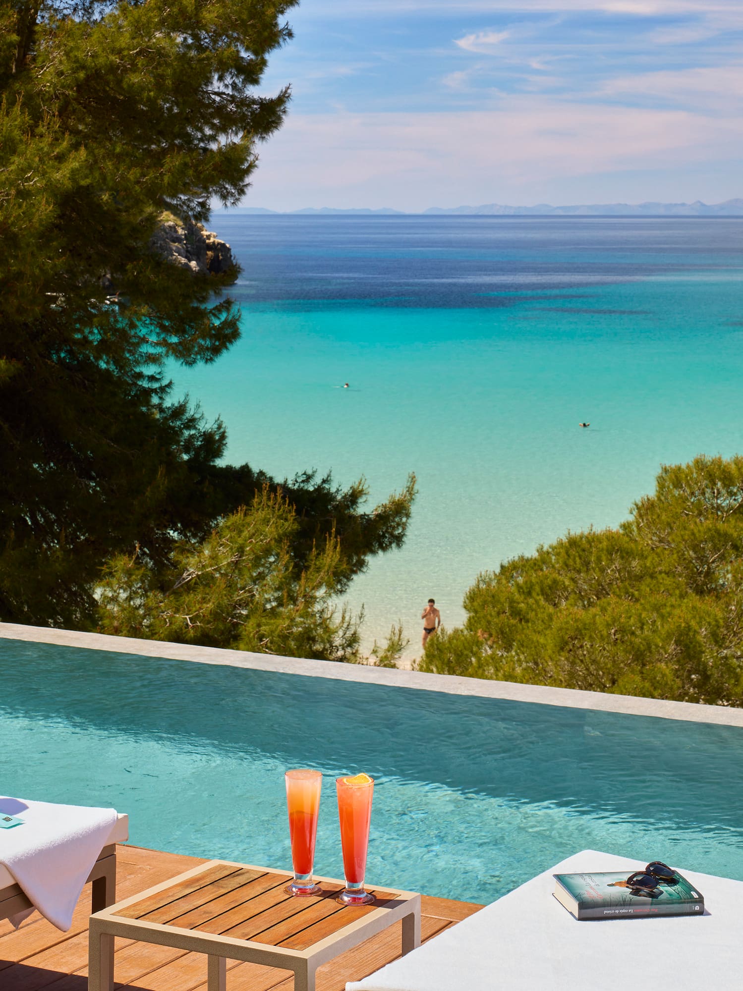 a pool with a beach view and a boat in the water