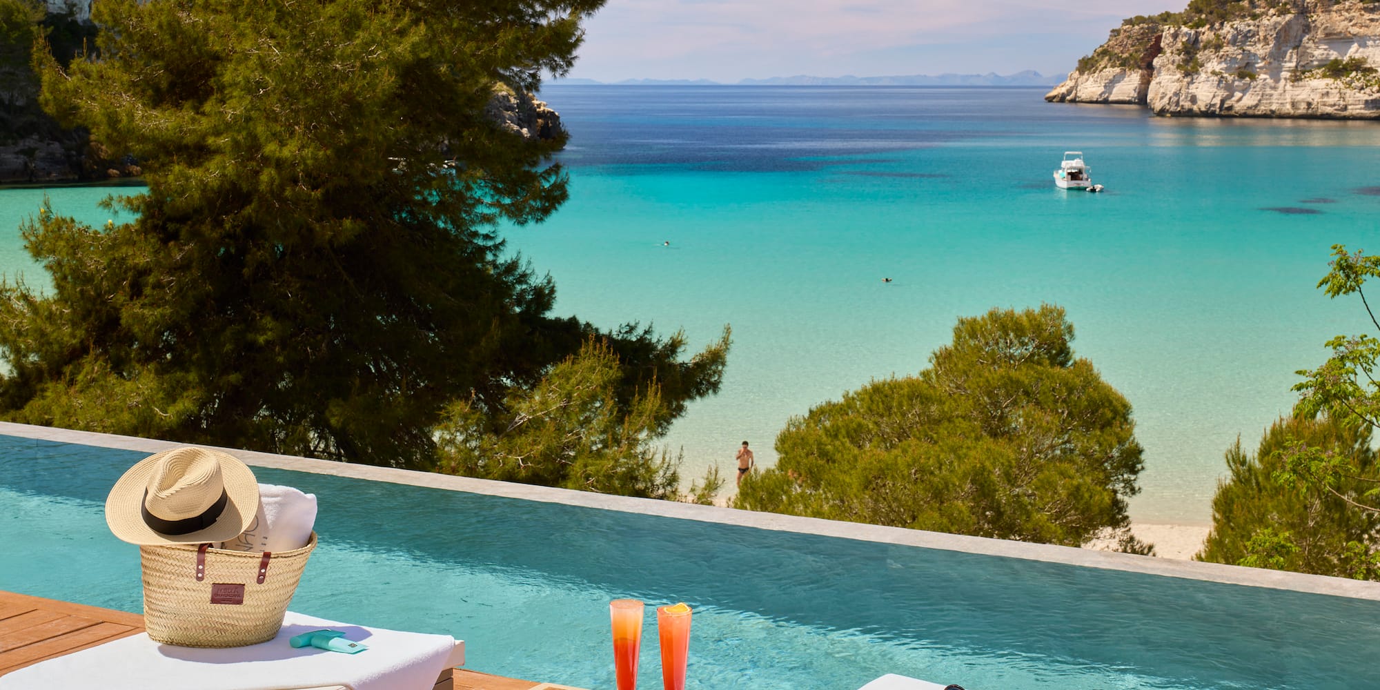 a pool with a beach view and a boat in the water