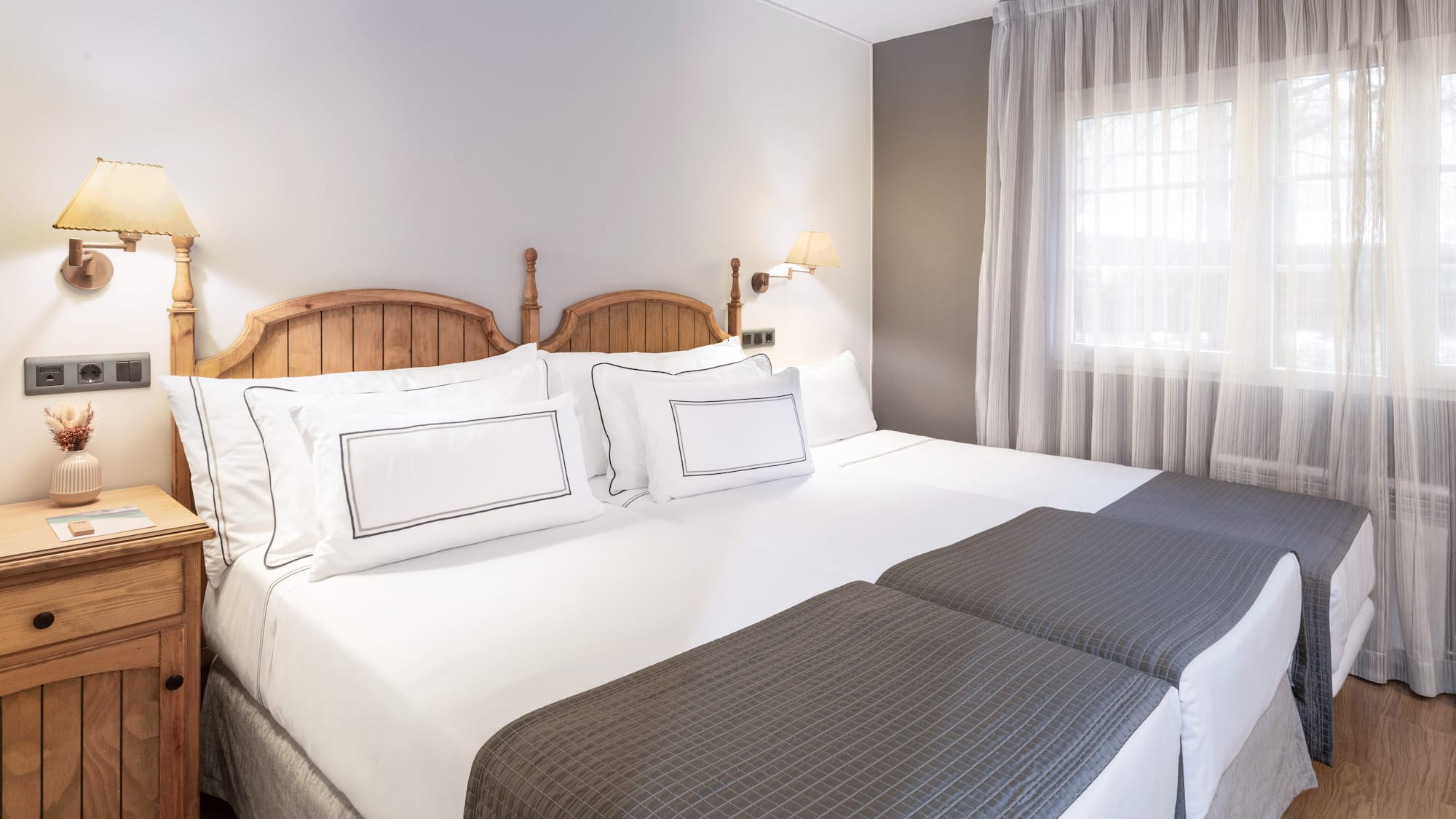 a bed with white sheets and a wooden headboard