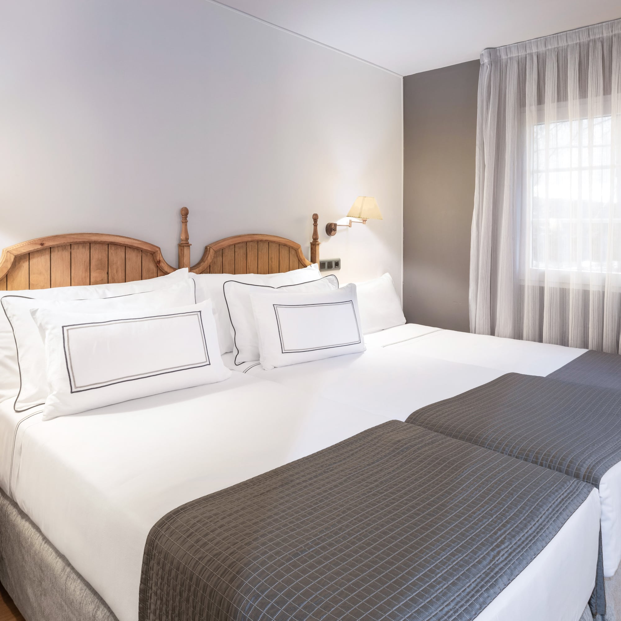 a bed with white sheets and a wooden headboard