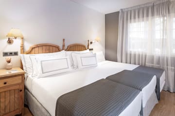 a bed with white sheets and a wooden headboard