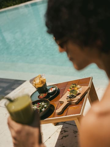 a person holding a drink and a plate of food