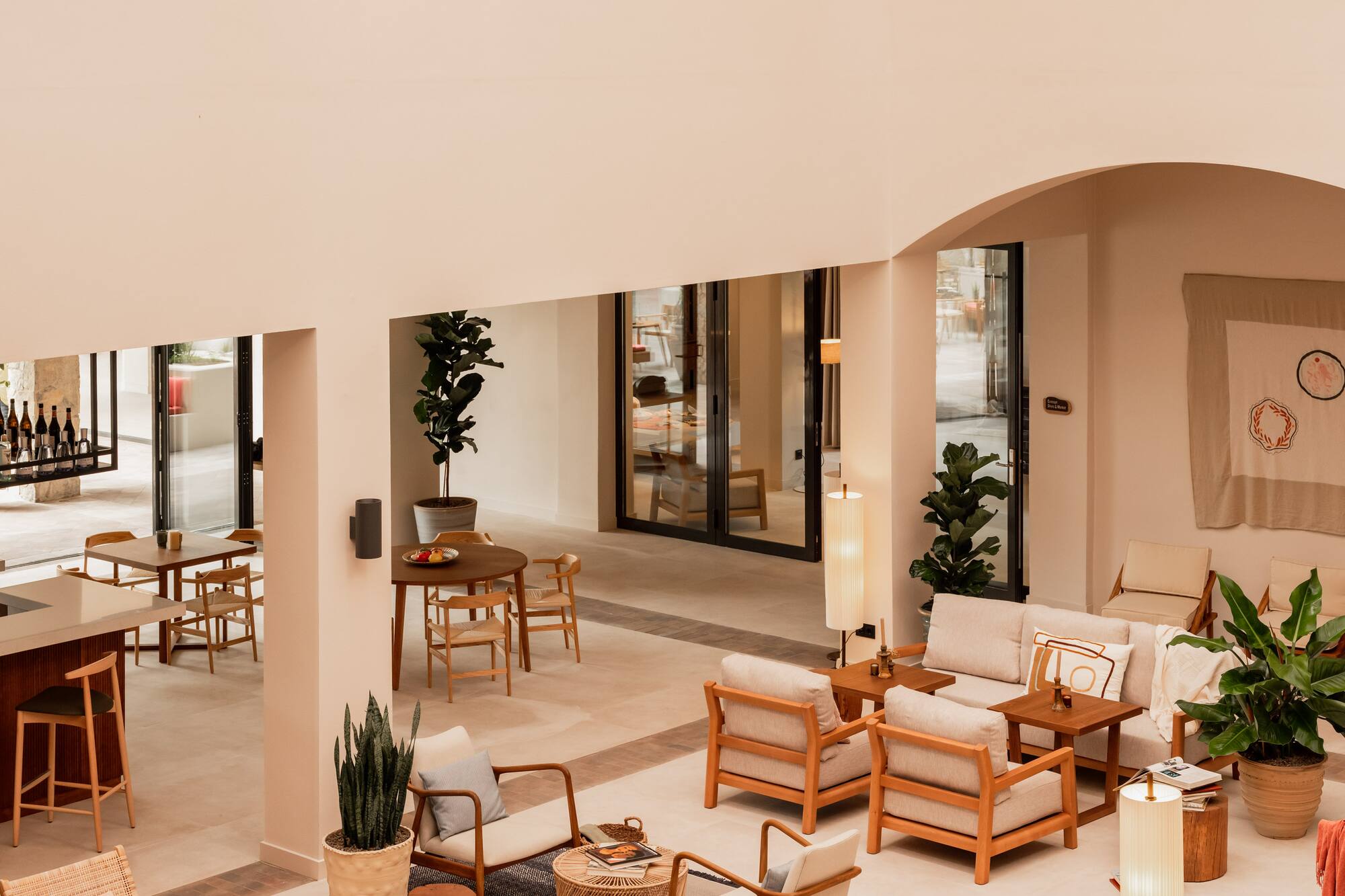 Bright, modern hotel lounge with comfortable wooden seating and potted plants.