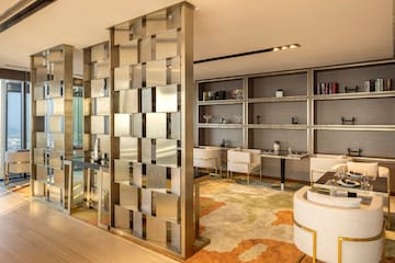 a room with a large screen and shelves