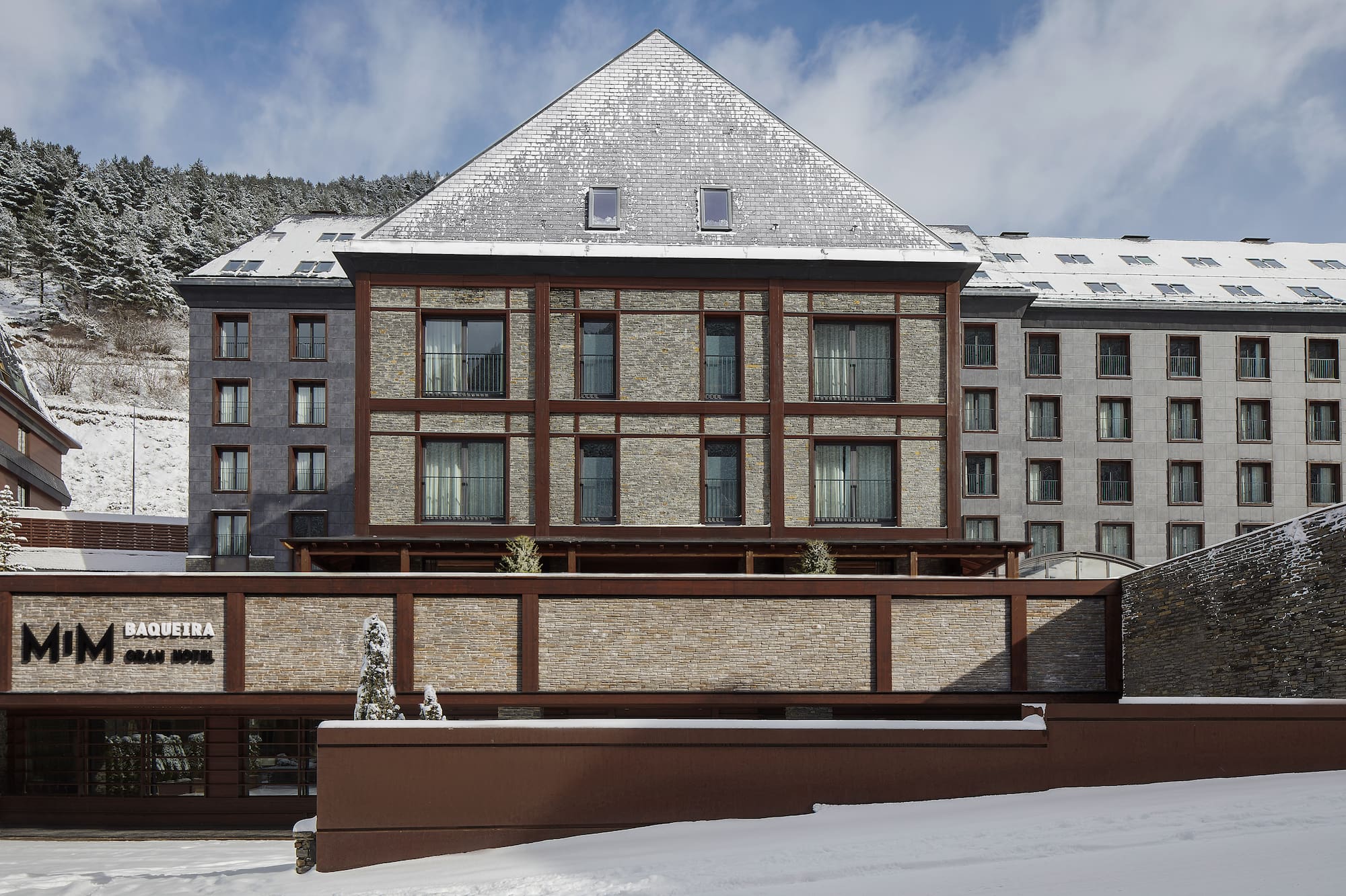 Mim Baqueira Gran Hotel exterior with snow. Mountain ski resort in winter.