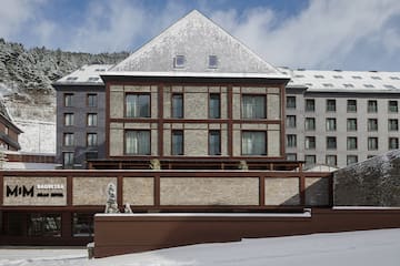 a building with a fence and snow