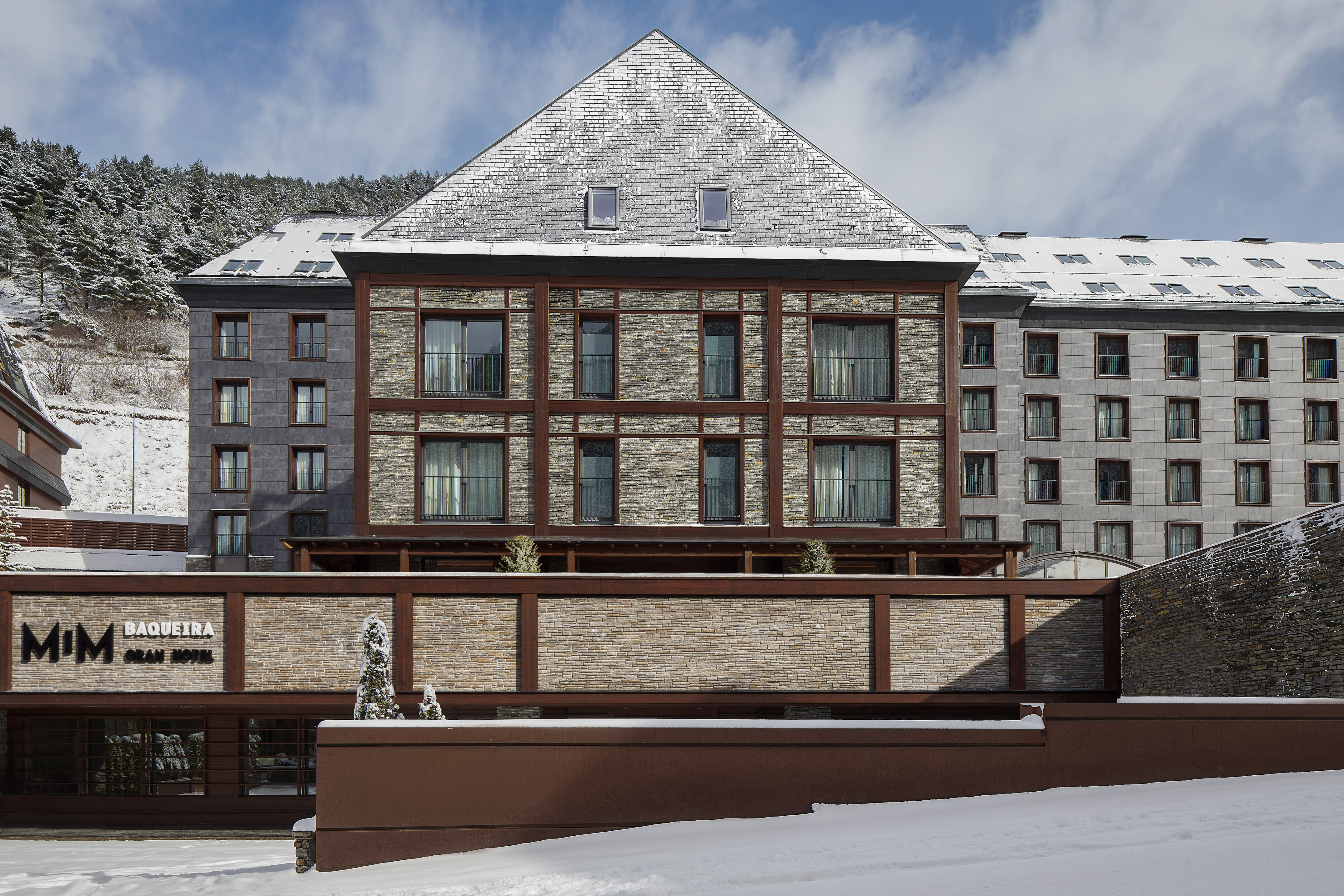 Mim Baqueira Gran Hotel exterior with snow. Mountain ski resort in winter.