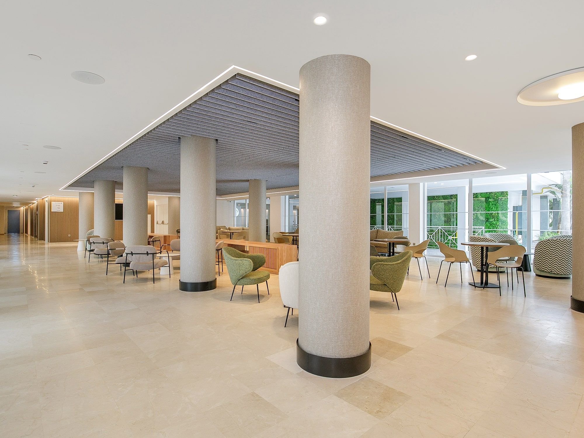 a large room with a large column and chairs